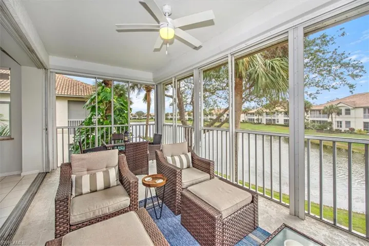 Sunroom with ceiling fan and a water view