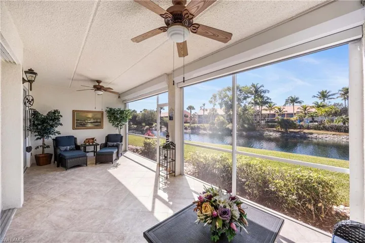 Sunroom featuring a textured ceiling and a water view
