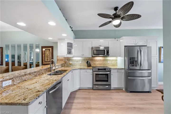 Kitchen featuring stainless steel appliances, granite  countertops, glass insert cabinets, new luxury plank flooring