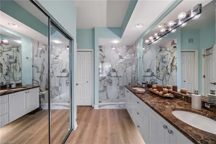 Bathroom with two vanities, double vanity, and light wood-style floors