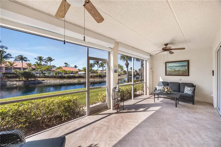 Sunroom / solarium with a water view and a textured ceiling