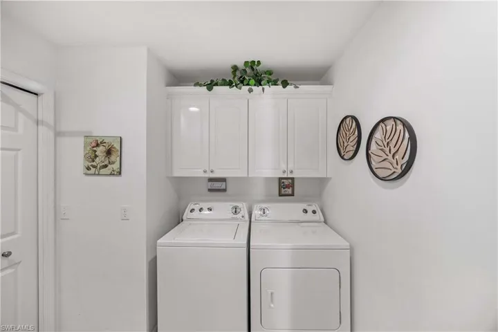 Interior laundry room featuring additional  cabinet space and separate washer and dryer