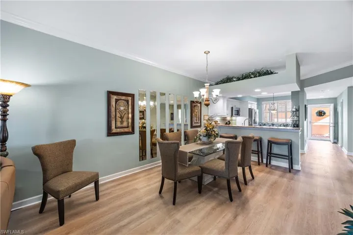 Dining room featuring ornamental molding, a chandelier, and light wood-style flooring