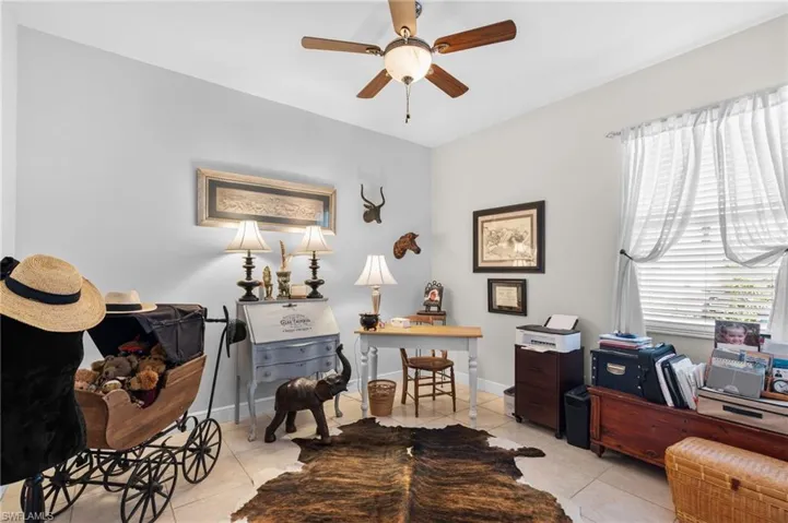 Guest bedroom with ceiling fan and light tile patterned floors
