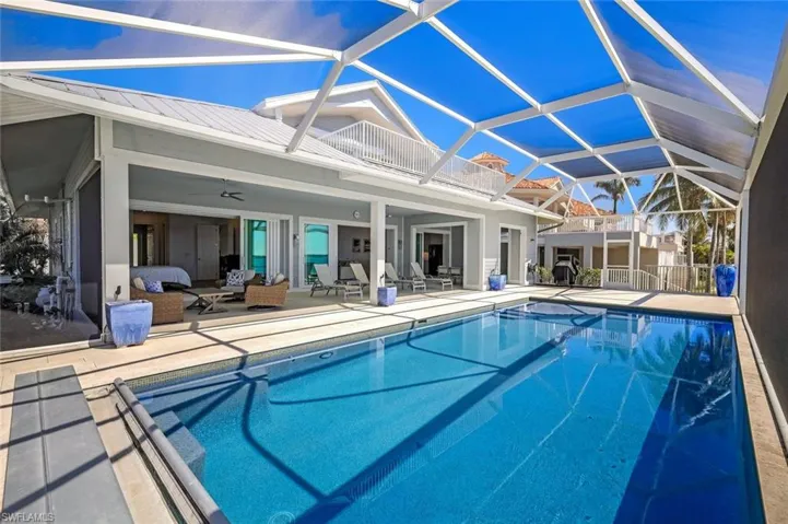 South facing oversized pool deck with extensive seating + dining areas for entertaining