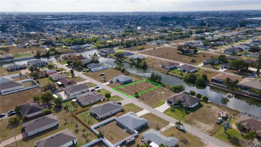 Aerial view of property and surrounding area featuring nearby suburban area and property parcel outlined