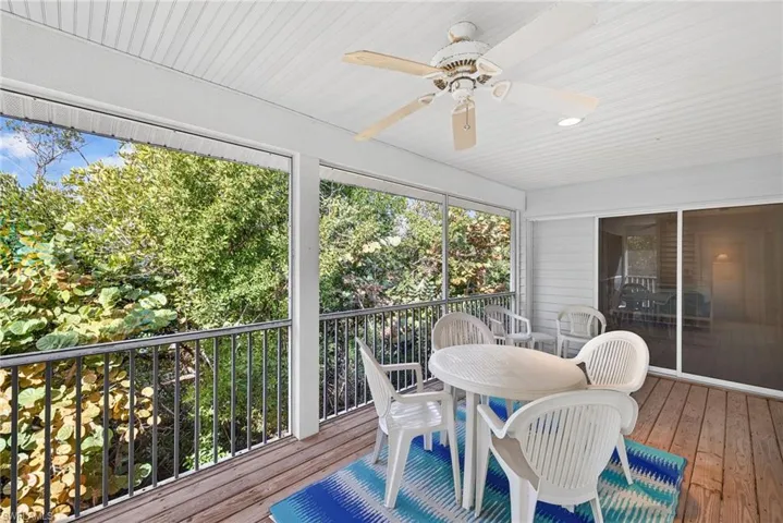 Sunroom / solarium with a ceiling fan and outdoor dining area