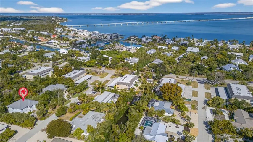 Aerial perspective of suburban area featuring a notable bridge and a nearby body of water