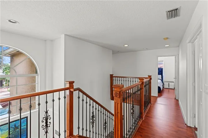 Hallway featuring dark hardwood / wood-style flooring and a textured ceiling