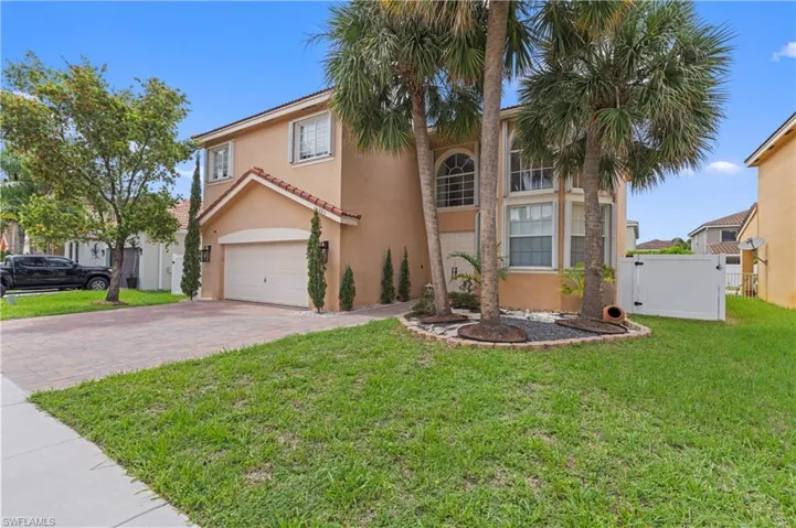 Mediterranean / spanish-style home featuring a garage and a front lawn
