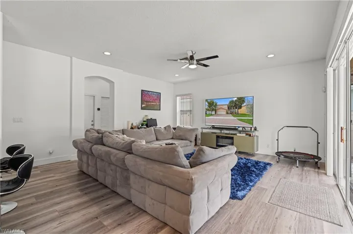Living room with light hardwood / wood-style floors and ceiling fan