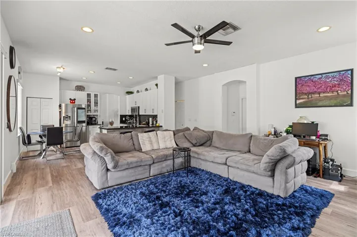 Living room with ceiling fan and light hardwood / wood-style flooring