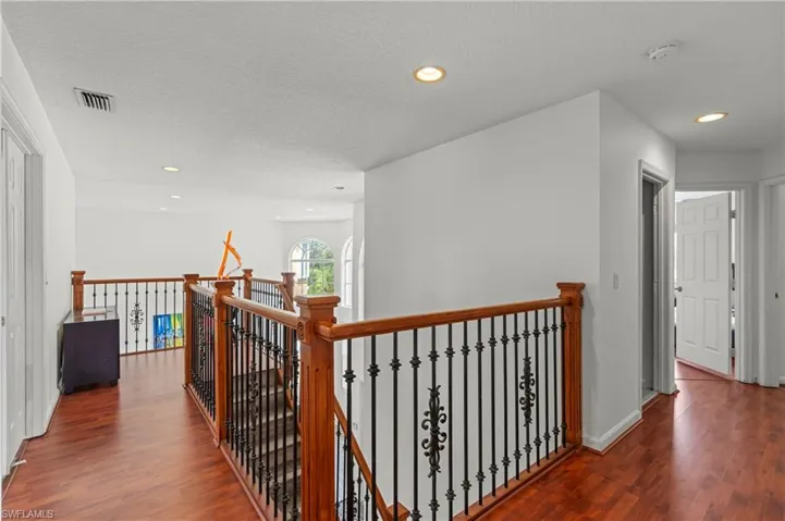 Corridor with dark hardwood / wood-style flooring and a textured ceiling