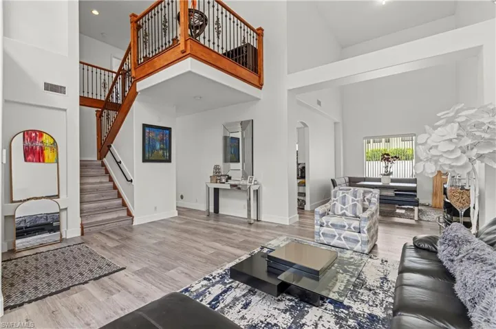Living room with hardwood / wood-style flooring and a towering ceiling