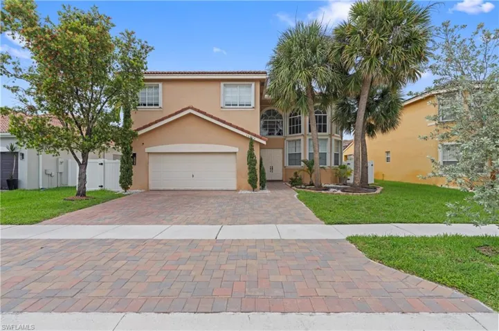 Mediterranean / spanish home with a garage and a front lawn