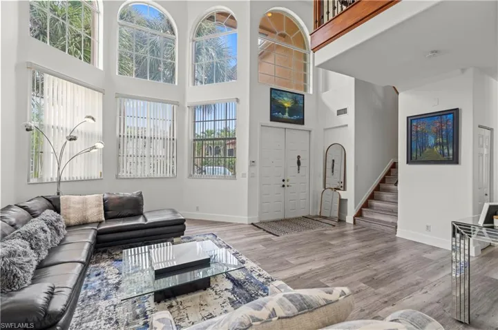 Living room featuring wood-type flooring and a high ceiling