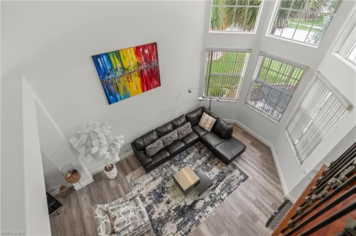 Living room with wood-type flooring and a high ceiling
