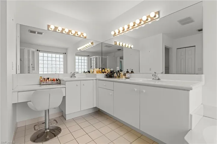 Bathroom featuring tile patterned floors and double sink vanity