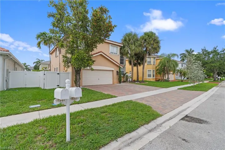 View of front of home with a garage and a front lawn