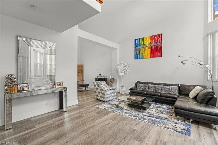 Living room featuring hardwood / wood-style floors and a towering ceiling