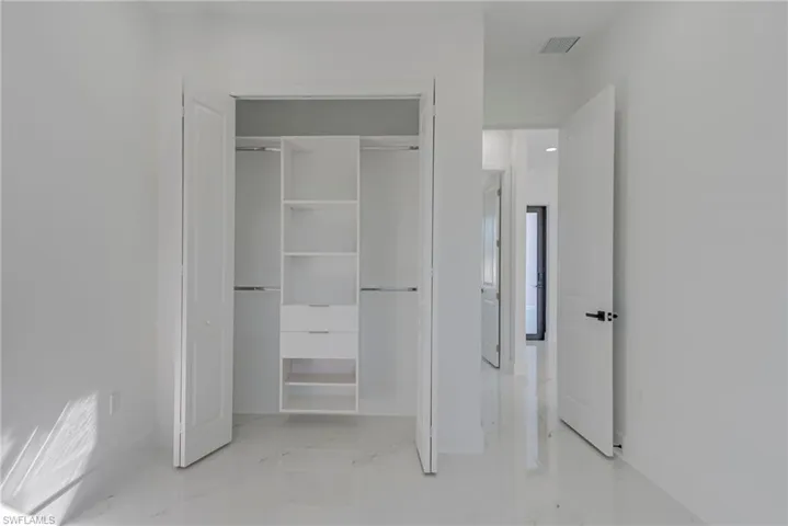 Unfurnished bedroom featuring a closet and light marble finish floors