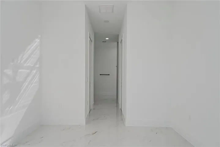 Hall with baseboards and recessed lighting