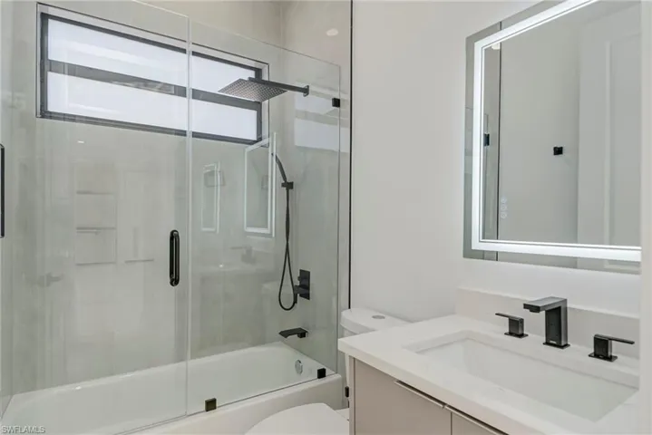 Full bath featuring vanity and shower / bath combination with glass door