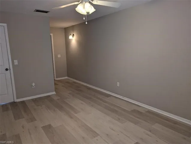 Empty room featuring ceiling fan, light wood-style flooring, baseboards, and visible vents