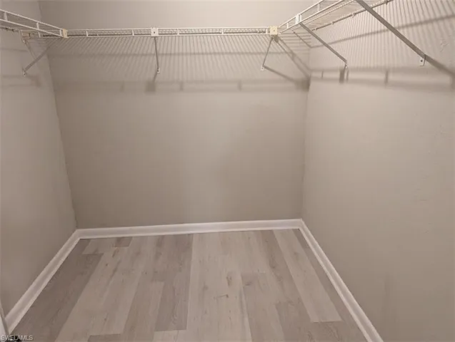 Walk in closet with wood finished floors