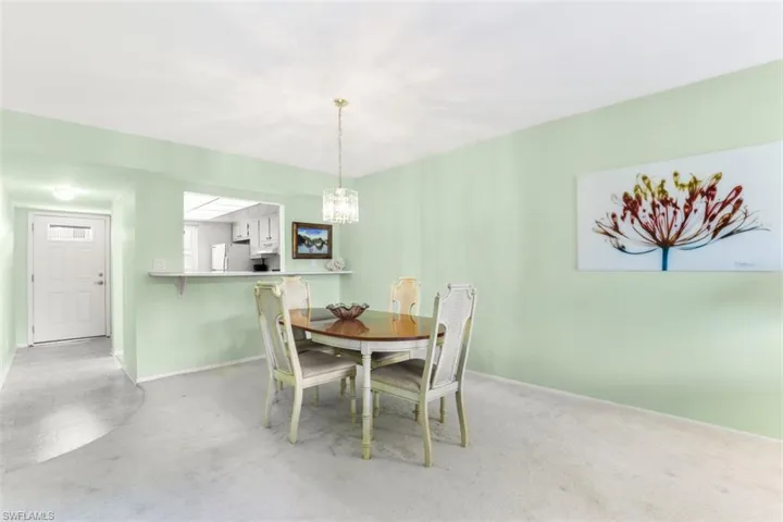 Carpeted dining space featuring a chandelier