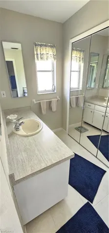 Bathroom featuring tile patterned floors, plenty of natural light, and vanity
