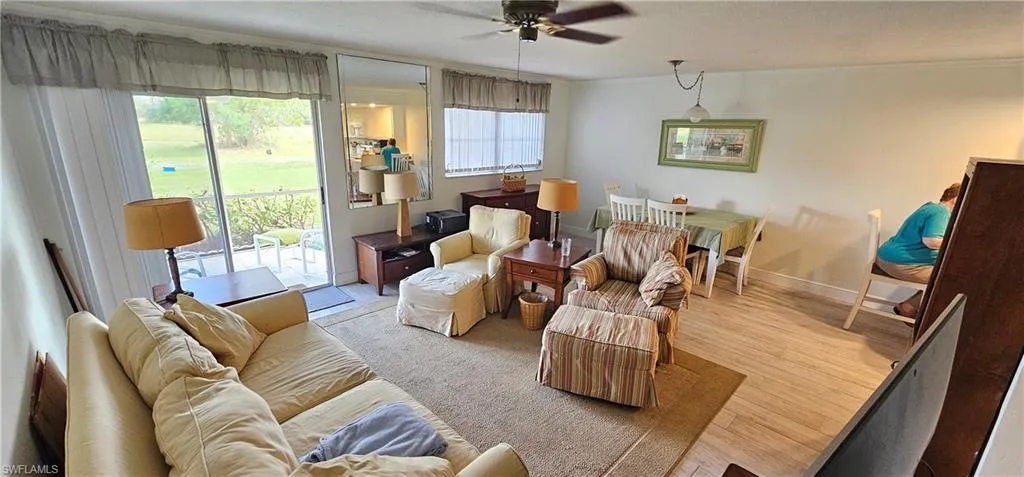 Living room featuring light hardwood / wood-style floors, ceiling fan, and ornamental molding