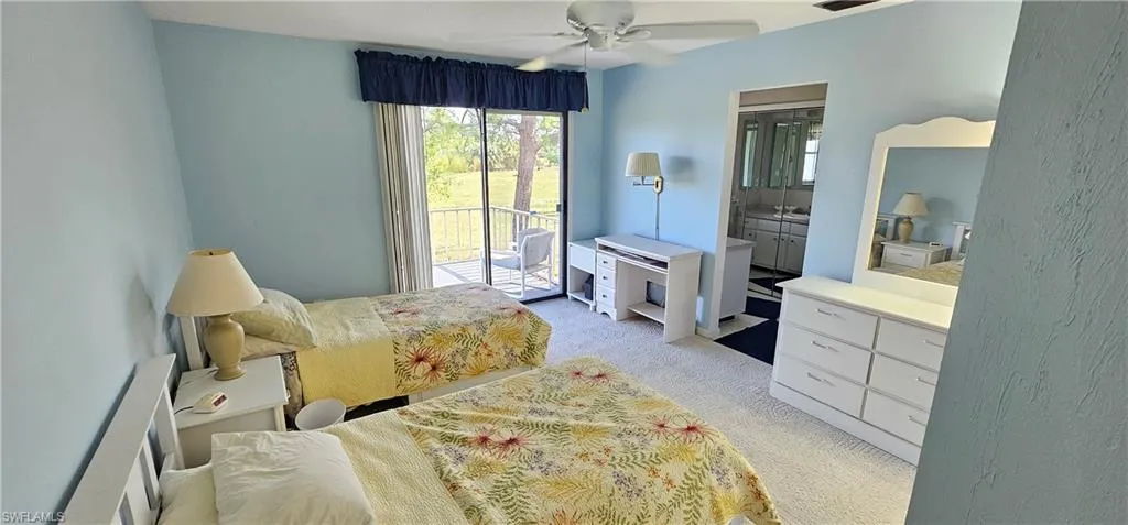 Carpeted bedroom with connected bathroom, access to outside, and ceiling fan