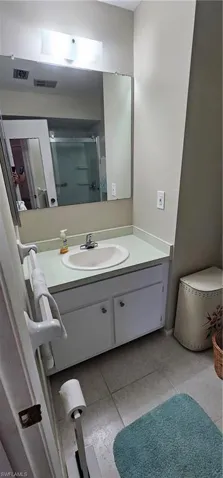 Bathroom featuring vanity, tile patterned floors, and a shower with door