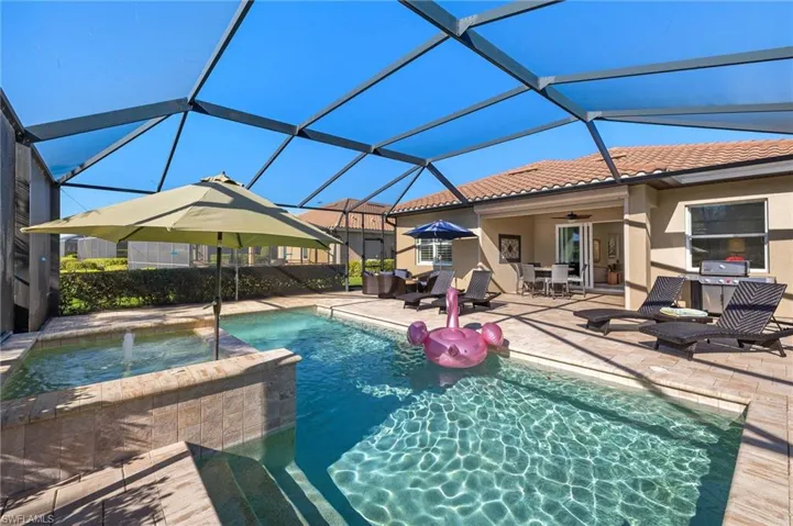 View of swimming pool featuring a pool with connected hot tub, a lanai, outdoor dining area, ceiling fan, and a patio area