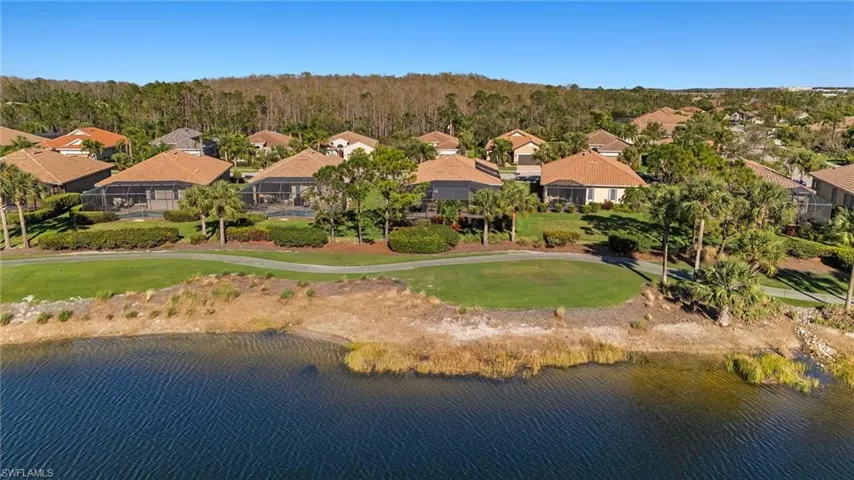 Drone / aerial view with a residential view, view of golf course, and a water view