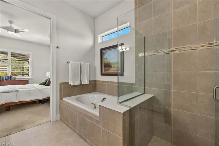 Ensuite bathroom with a shower stall, tile patterned floors, a healthy amount of sunlight, and ensuite bathroom