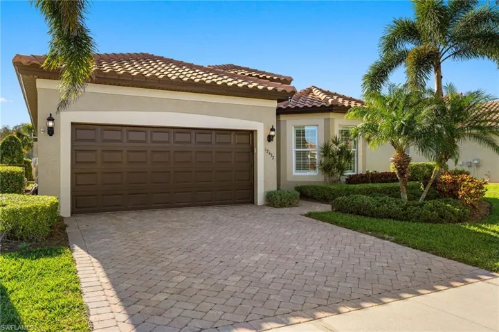 Mediterranean / spanish-style house with stucco siding, a tiled roof, decorative driveway, and a garage