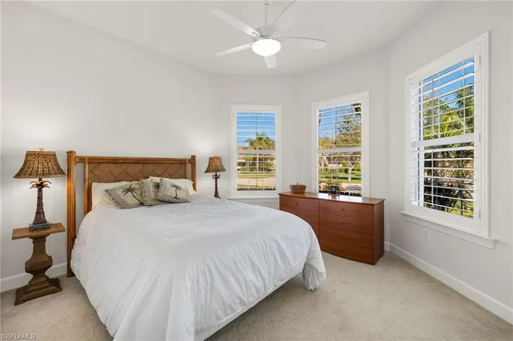 Bedroom with baseboards, light colored carpet, and ceiling fan