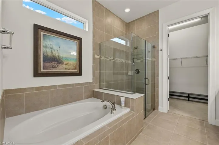 Full bathroom with tile patterned floors, a garden tub, recessed lighting, a shower stall, and a spacious closet