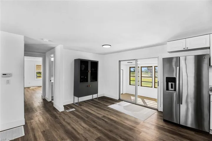 Unfurnished dining area featuring dark wood-style floors and plenty of natural light