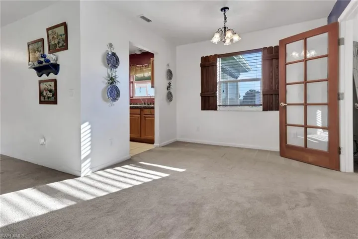 Unfurnished dining area featuring light carpet and a chandelier