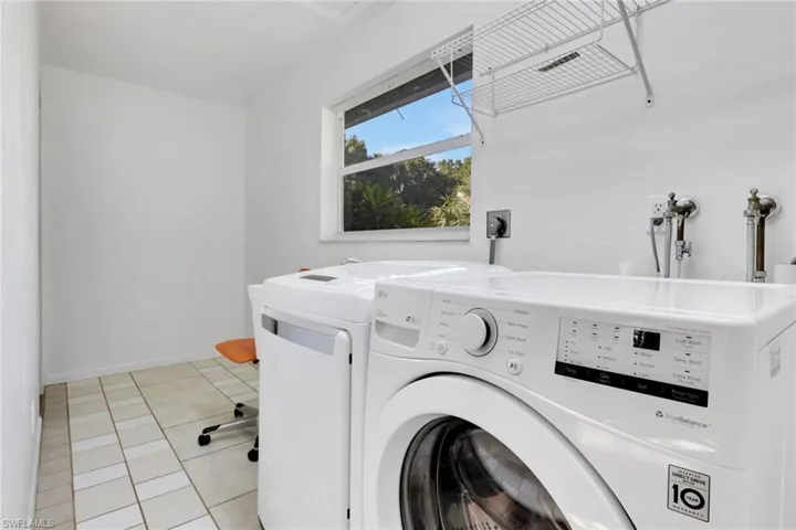 Laundry room featuring light tile patterned floors and separate washer and dryer