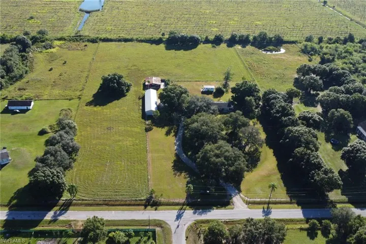 View of rural area featuring a pastoral area and rows of crops