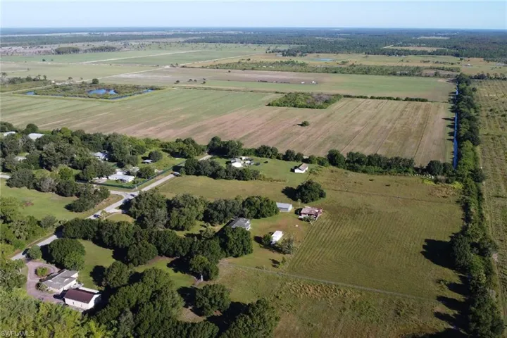 Aerial view of property and surrounding area featuring rural landscape and large plots for crops