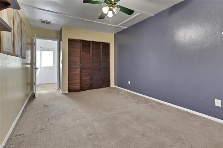Unfurnished bedroom with carpet floors, a ceiling fan, and a closet