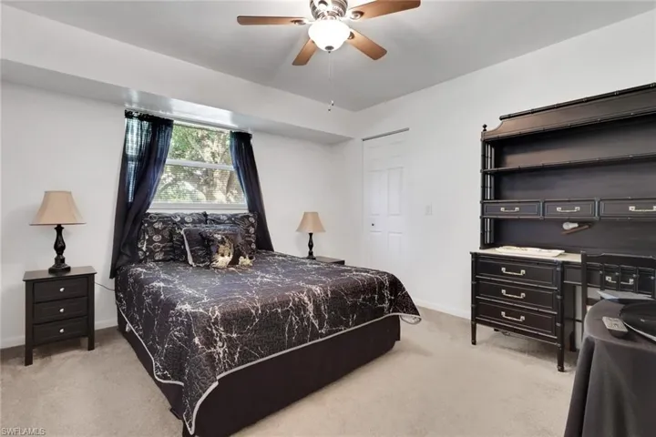 Bedroom featuring light colored carpet, ceiling fan, and a closet