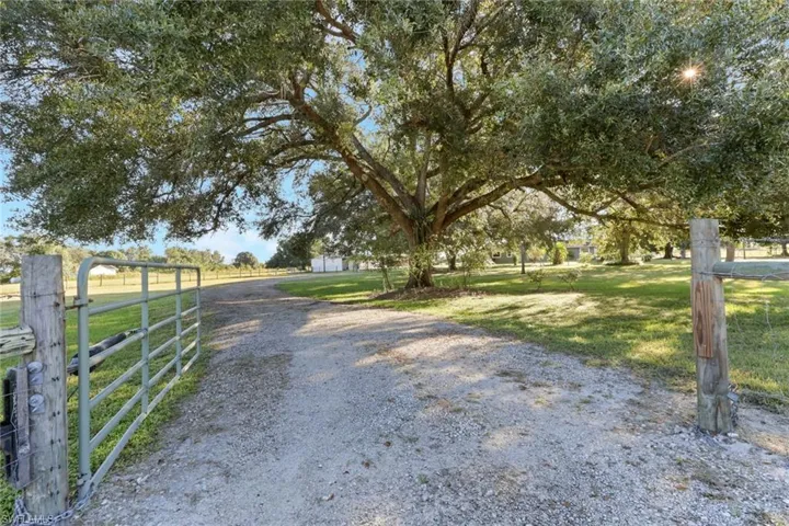 View of dirt / gravel road featuring a gated entry and a view of countryside