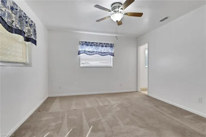 Unfurnished room with light carpet and a ceiling fan
