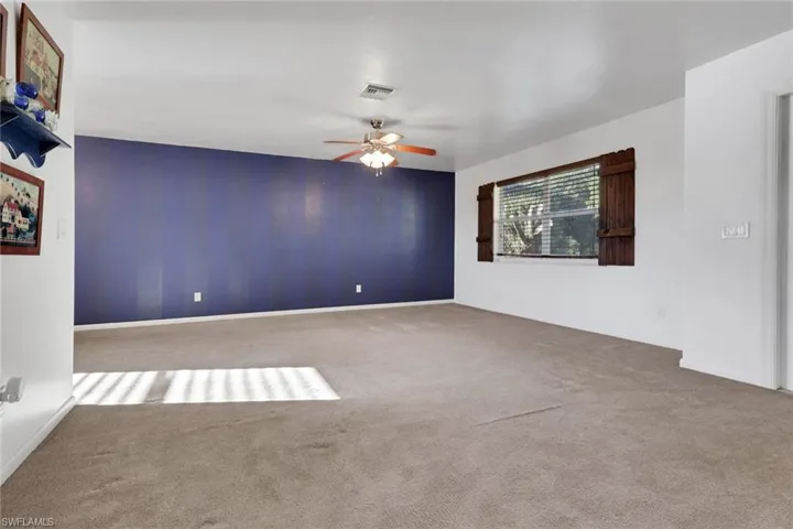 Empty room with carpet flooring and ceiling fan